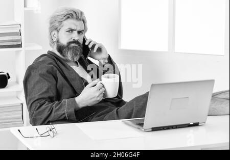 Sharing fresh ideas. relaxed businessman in home office. online agile business. man using laptop indoor. bearded man looking at his laptop screen Stock Photo