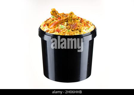 Chicken Bucket Biryani, Kerala dum chicken biryani arranged in a black bucket container with white textured background. Stock Photo