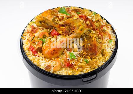 Chicken Bucket Biryani, Kerala dum chicken biryani arranged in a black bucket container with white textured background. Stock Photo