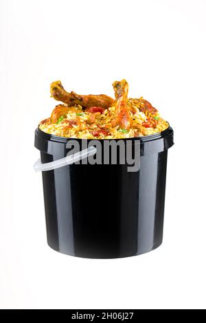 Chicken Bucket Biryani, Kerala dum chicken biryani arranged in a black bucket container with white textured background. Stock Photo