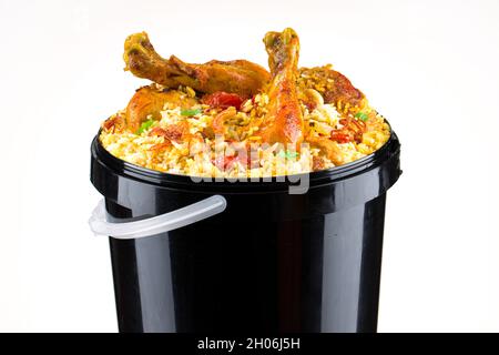 Chicken Bucket Biryani, Kerala dum chicken biryani arranged in a black bucket container with white textured background. Stock Photo