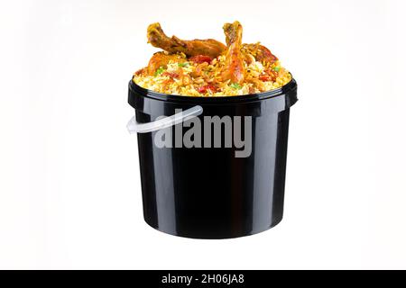 Chicken Bucket Biryani, Kerala dum chicken biryani arranged in a black bucket container with white textured background. Stock Photo