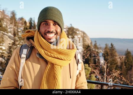 Young cheerful traveler of African ethnicity enjoying adventure on frosty winter day Stock Photo