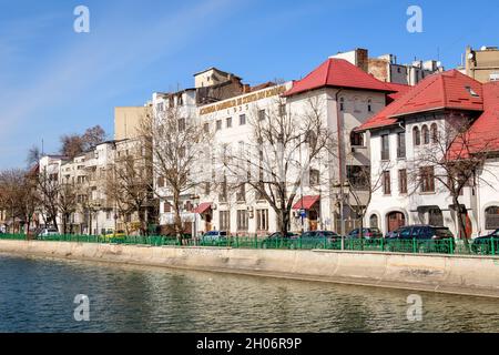 Bucharest, Romania, 13 February 2021 - Landscape with large old trees and old buildings near Dambovita river and clear blue sky in the center of Bucha Stock Photo