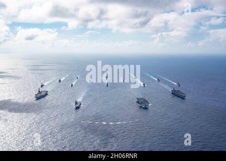 Philippine Sea, United States. 03 October, 2021. Formation of multi-national carrier strike groups sail in formation during exercises October 3, 2021, in the Philippine Sea. Carriers from left to right: U.S. Navy Nimitz-class aircraft carrier USS Carl Vinson, Japanese Hyuga-class helicopter destroyer JS Ise, British Royal Navy aircraft carrier HMS Queen Elizabeth, and the U.S. Navy Nimitz-class aircraft carrier USS Ronald Reagan.  Credit: MC2 Jason Tarleton/U.S. Navy/Alamy Live News Stock Photo