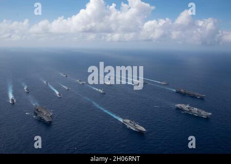 Philippine Sea, United States. 03 October, 2021. Formation of multi-national carrier strike groups sail in formation during exercises October 3, 2021, in the Philippine Sea. Carriers from left to right: U.S. Navy Nimitz-class aircraft carrier USS Carl Vinson, Japanese Hyuga-class helicopter destroyer JS Ise, British Royal Navy aircraft carrier HMS Queen Elizabeth, and the U.S. Navy Nimitz-class aircraft carrier USS Ronald Reagan.  Credit: MC2 Jason Tarleton/U.S. Navy/Alamy Live News Stock Photo