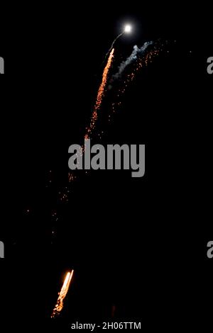 Fireworks in the night dark sky exploding with colorful glittering light during celebration event. Stock Photo