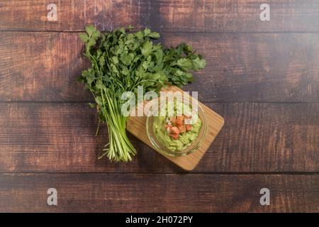 Guacamole on a cutting board with fresh cilantro. Stock Photo