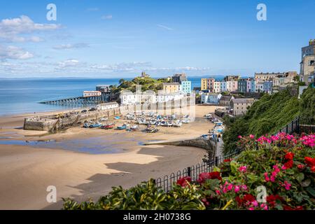 Tenby Harbour, Pembrokeshire, Wales, the United Kingdom. Boats on the beach at low tide. Colorful buildings of popular Welsh resort on a sunny Summer day. Stock Photo