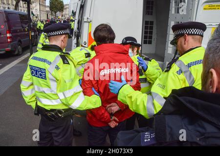 London, United Kingdom. 11th October 2021. Greenpeace activists locked themselves to barrels outside Downing Street in protest against the Cambo oil field. Stock Photo