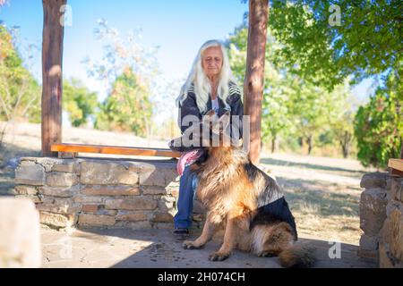 A woman takes a German Shepherd dog for a walk in nature Stock Photo