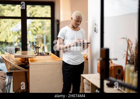 Latin man choosing temperature on thermostat Stock Photo