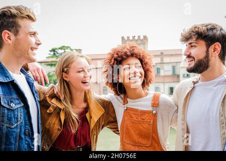 Group of friends happy  laughing together - Group of multiracial guys having fun on the city street - Portrait of four students from different culture Stock Photo