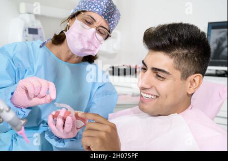 Dentist shows invisible braces aligner. Dental consultation in an orthodontic clinic. High quality photo. Stock Photo