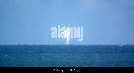 looking along a line of 150m high wind turbines in action, Gwynt y Môr (Sea wind) 576-megawatt offshore electricity generating wind farm; Colwyn Bay Stock Photo