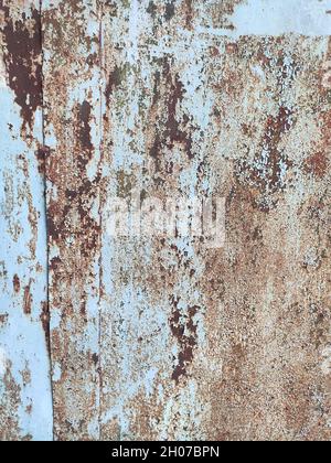 Corroded metal background. Rusted white painted metal wall. Rusty metal background with streaks of rust. Rust stains. The metal surface rusted spots. Stock Photo