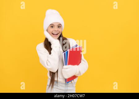 kid with workbook on yellow background. happy childhood. teen girl on holiday. Stock Photo