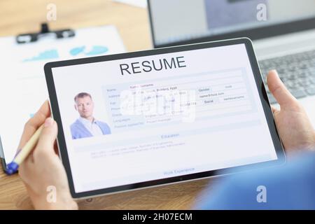 Manager examines applicant electronic questionnaire on tablet Stock Photo