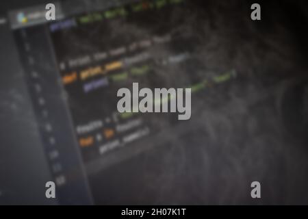 Python Hello World code on screen blurry background image Stock Photo