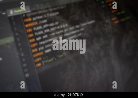 Docker file Hello World code on screen blurry background image Stock Photo