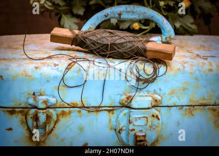 Old String on Top of Rusty Blue Metal Tool Box Stock Photo