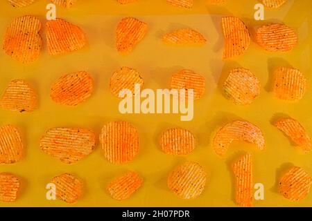 Collection of fried potato chips snack on yellow background. Chilli and potato taste. Junk food Stock Photo