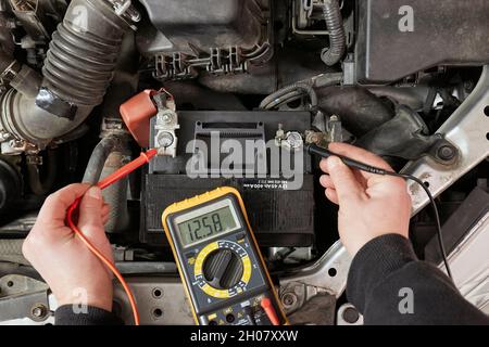 Checking car battery voltage on a car Stock Photo