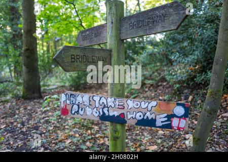 Wooden bridleway sign with Please Take Your Rubbish Home message attached. Stock Photo