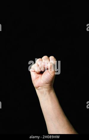 Vertical shot of a hand showing the letter S on a dark background Stock Photo