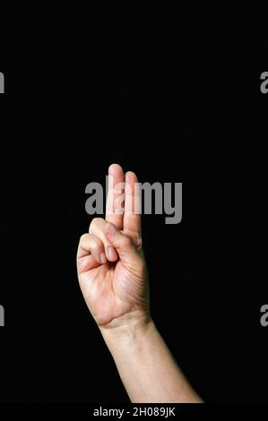 Vertical shot of a hand showing the letter U on a dark background Stock Photo