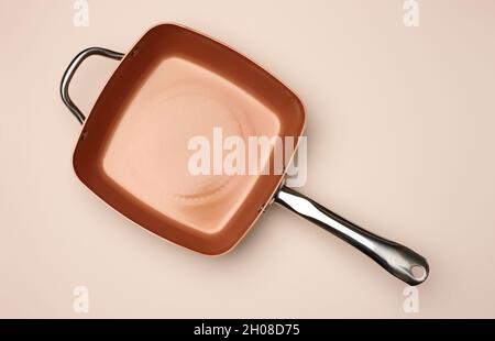 new copper deep frying pan on a beige background, top view Stock Photo