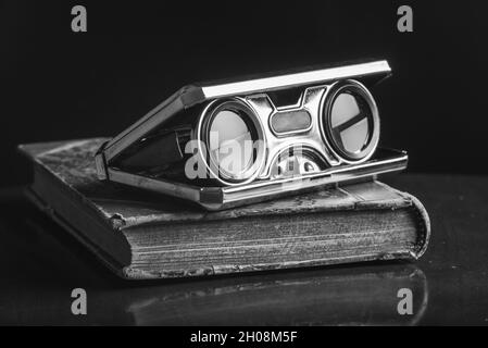 Closeup vintage folding opera glasses. Old compact binoculars. Stock Photo