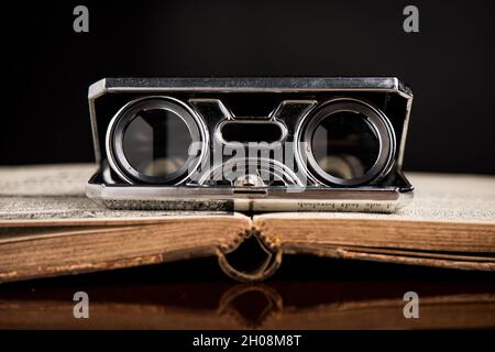 Closeup vintage folding opera glasses. Old compact binoculars. Stock Photo