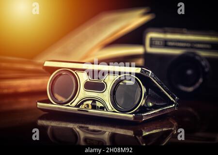 Closeup vintage folding opera glasses. Old compact binoculars. Stock Photo