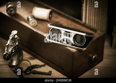 Closeup vintage folding opera glasses. Old compact binoculars. Stock Photo