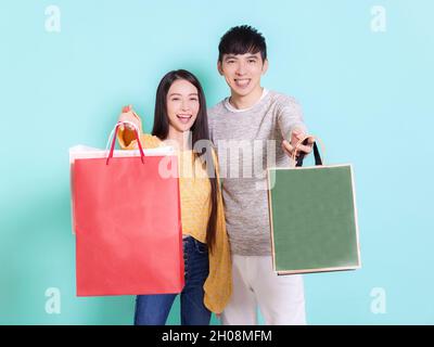 Happy couple showing shopping bags.Isolated on blue background. Stock Photo