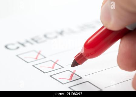Hand with red marker pen marking on checklist box Stock Photo