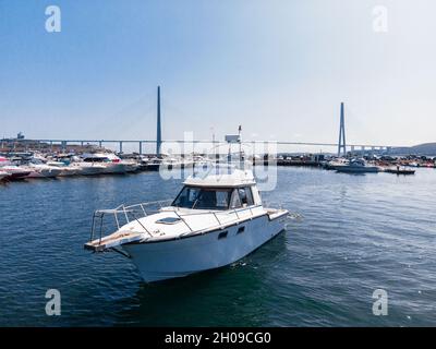 A white pleasure boat stands in the bay at sea, in the parking lot. Yacht background of other boats. Photo from a drone. Stock Photo