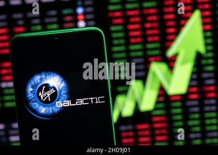 Virgin Galactic logo on the background of a large green arrow pointing up. Growthing stock price. Stock Photo