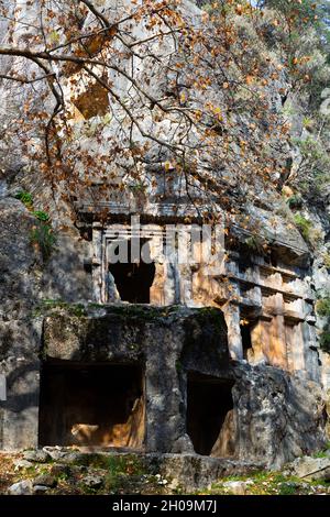 Ancient Lycian rock hewn tombs in stone cliff in Pinara, Turkey Stock Photo