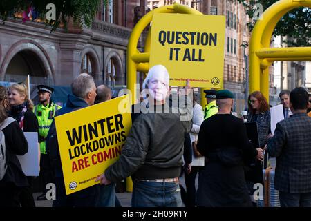 Tory Party Conference. Protester with banner text Question It All, Winter Lockdowns are Coming. Boris Johnson mask.