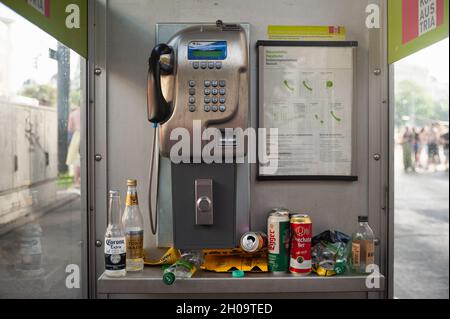 '15.06.2019, Austria, , Vienna - Empty bottles and drink cans in a littered Telekom Austria public phone booth during the rainbow parade (Europride) i Stock Photo