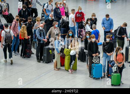 '02.07.2021, Germany, North Rhine-Westphalia, Duesseldorf - Duesseldorf Airport, vacation start in NRW, vacationers stand with suitcases in a queue of Stock Photo