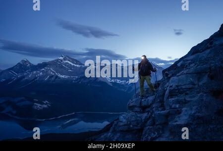 Hiker descending the mountain, during the nigh with shining headlamp, Rimwall Summit, Canada Stock Photo