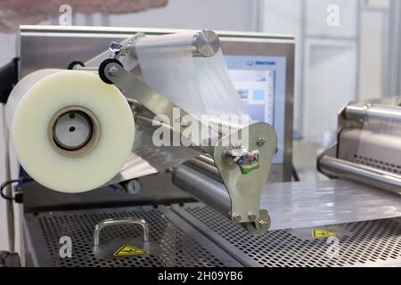 Stretched foil on packaging machine in food industry Stock Photo