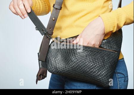 Woman take out from leather black bag  isolated clsoe up view Stock Photo