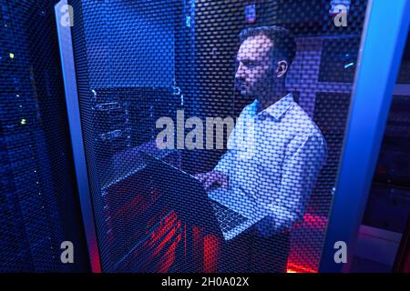 Professional system administrator maintaining data security in colocation center Stock Photo