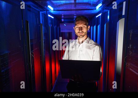 IT engineer working with laptop in data storage center Stock Photo