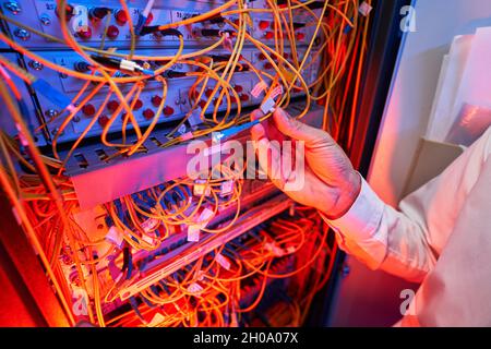 IT engineer connecting fiber-optic cable to server switch Stock Photo