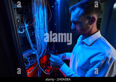 Server administrator putting twisted pair into crimping tool Stock Photo